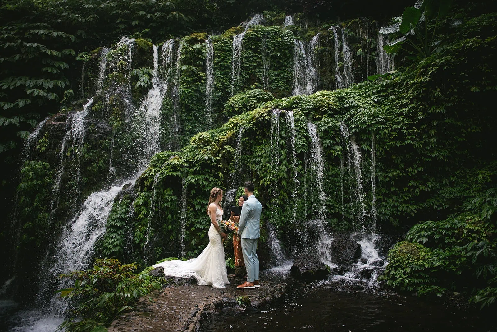 Bali elopement ceremony surrounded by jungle vines and soft waterfall mist