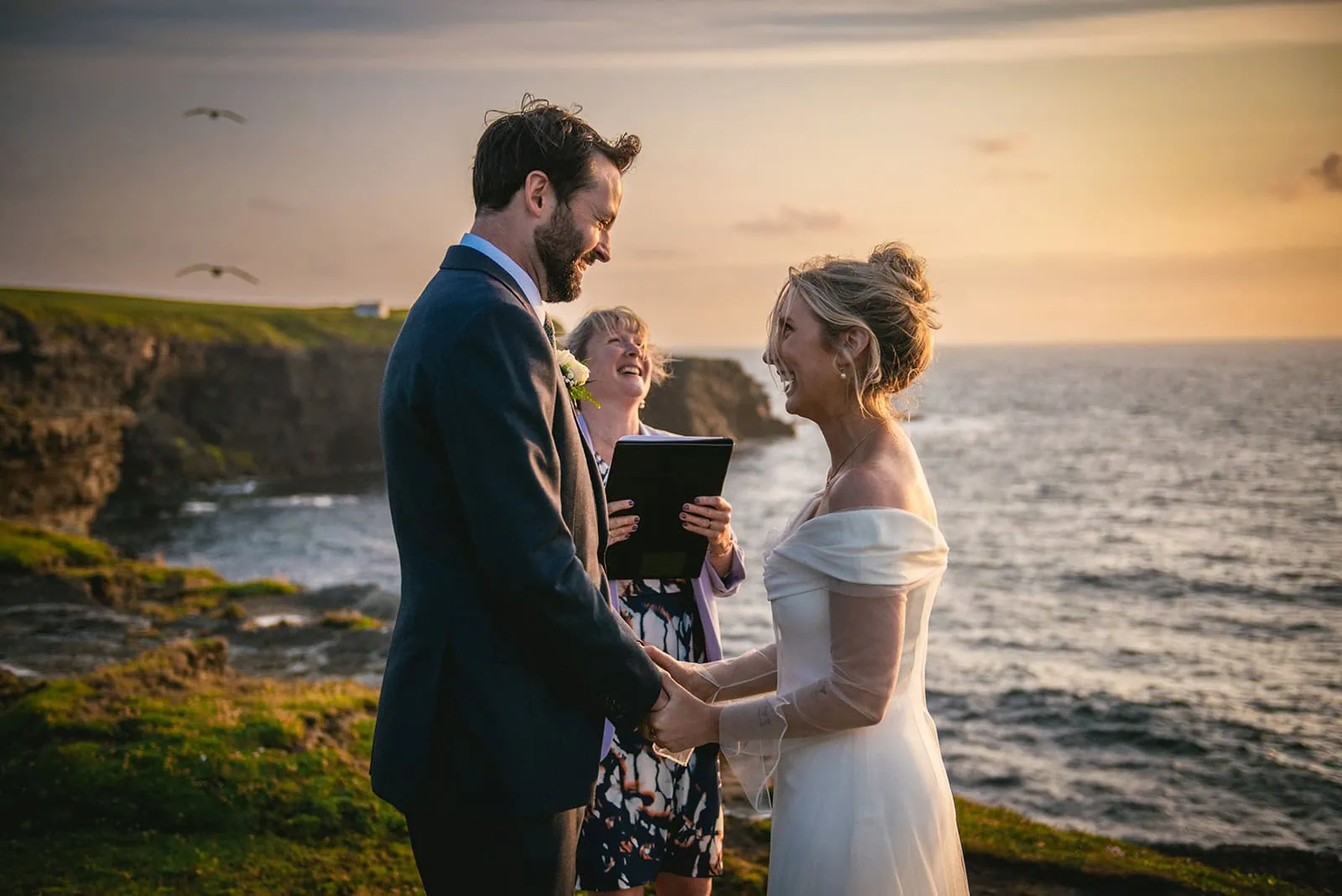 Laughter in the wind during this sunset elopement ceremony in Ireland