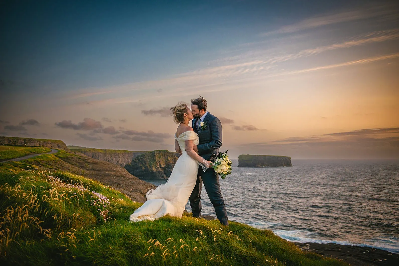 Romantic kiss at sunset on cliffs, the ocean witnessed their Ireland elopement