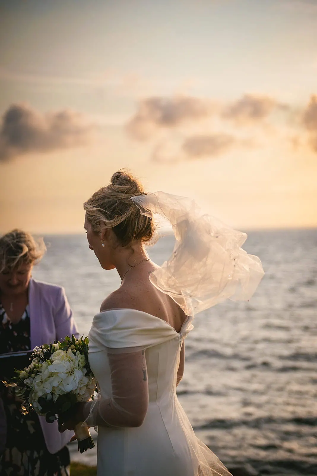 Wind teasing the veil during the cliffside ceremony of this Ireland elopement