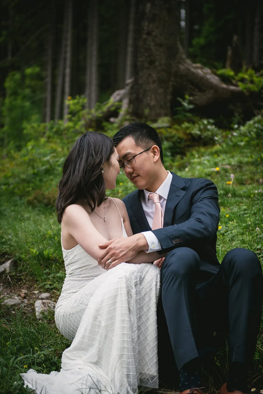 Tender embrace under the trees in their Oeschinensee elopement