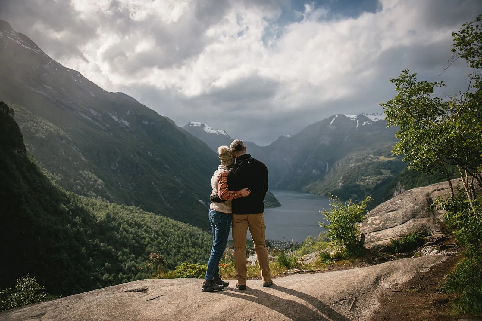 Tender embrace while gazing at the fjord during their elopement