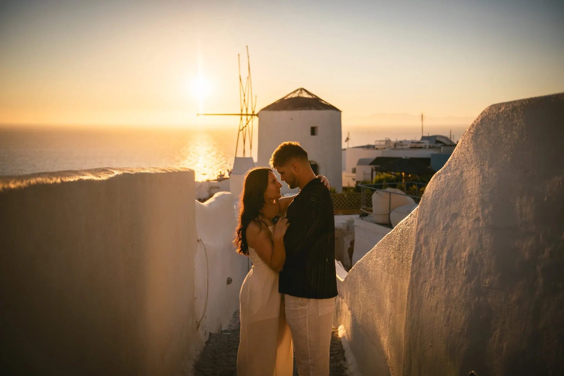 Romantic couple at sunset in Santorini, Greece, capturing an intimate elopement with iconic architecture in the background.