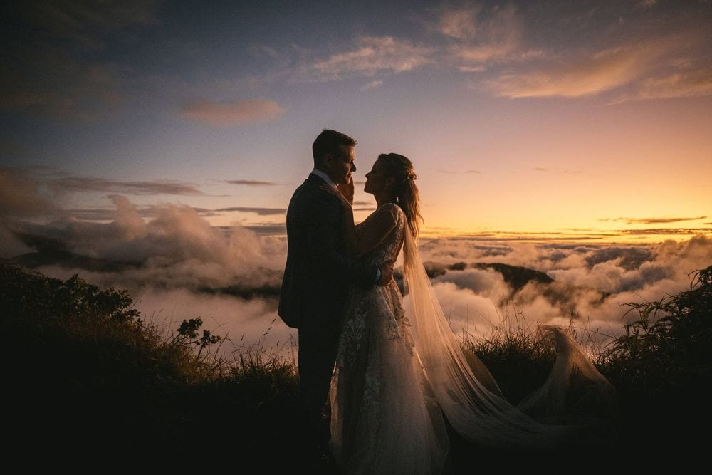Romantic couple eloping at sunset with ocean view on Big Island, Hawaii.