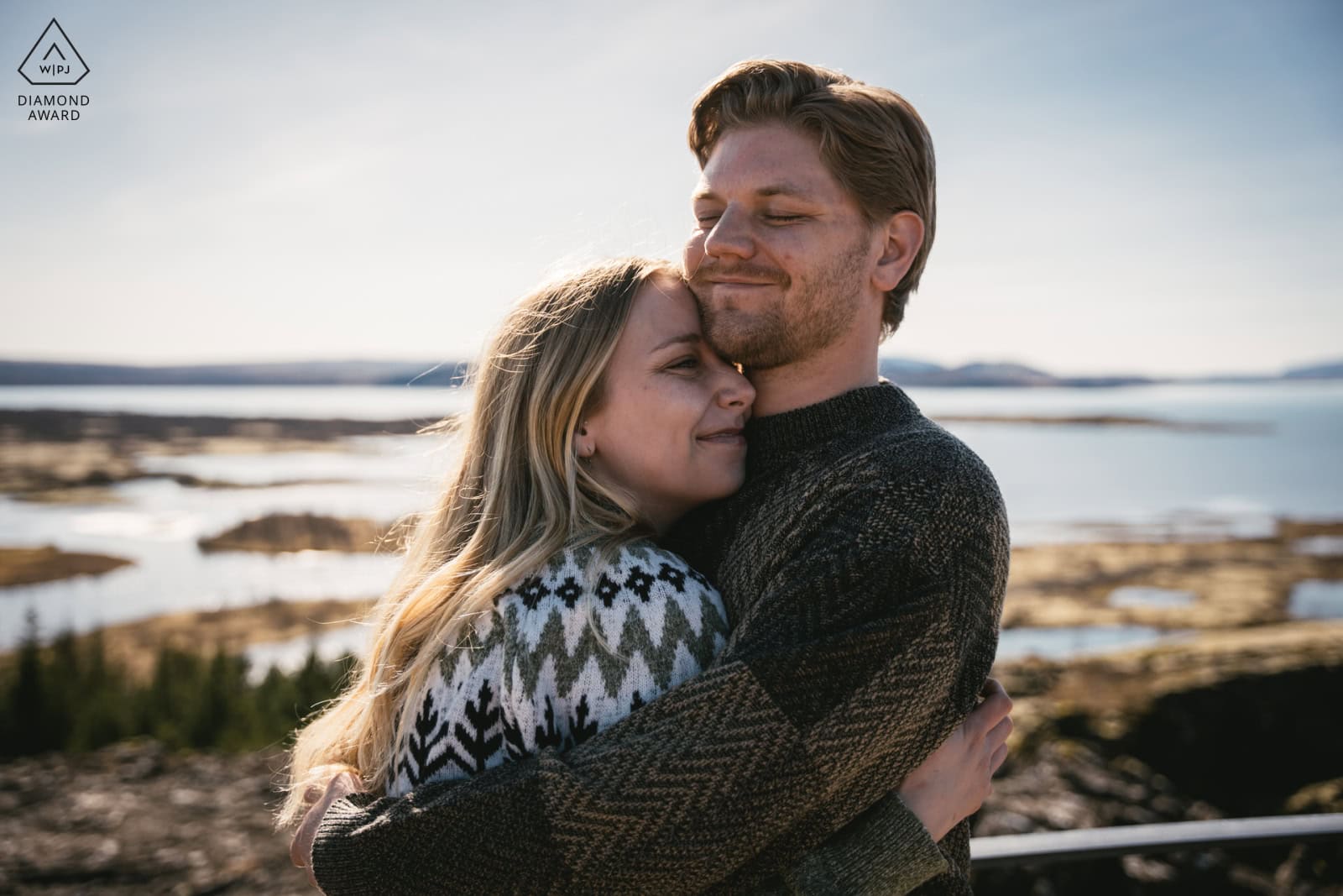 Elopement couple embracing outdoors in Iceland's scenic landscape.