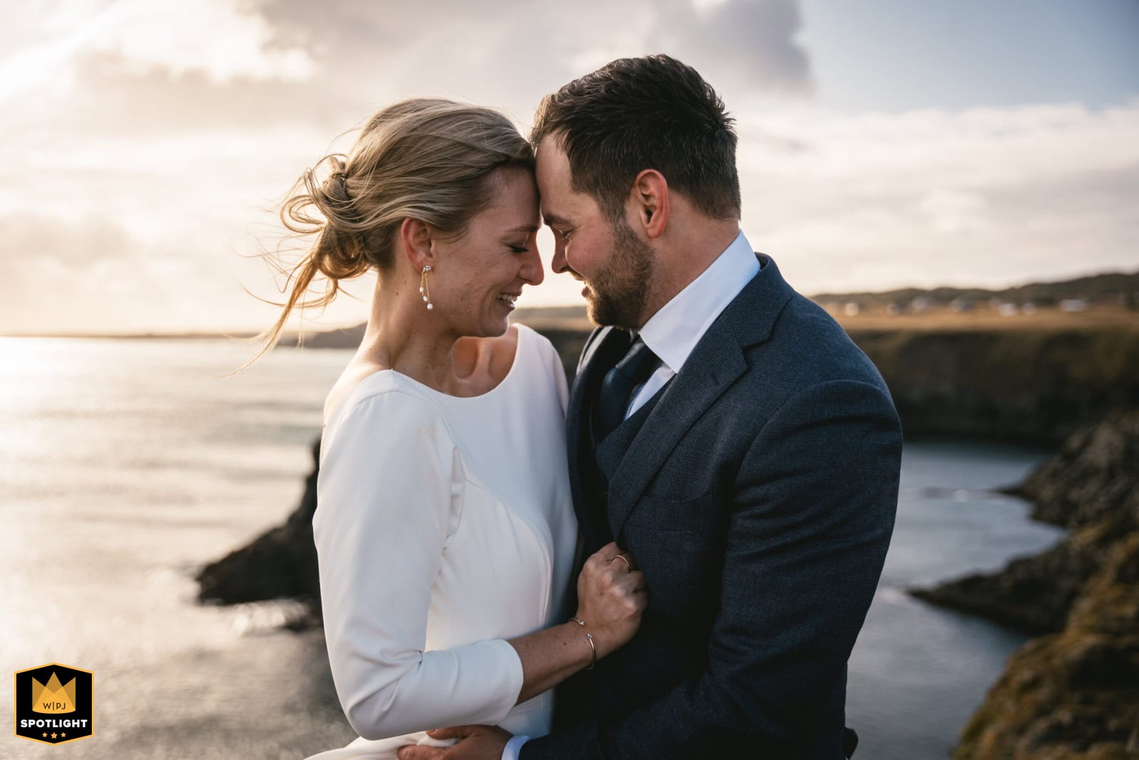 Romantic couple during an Iceland elopement at sunset, embracing by the coast.