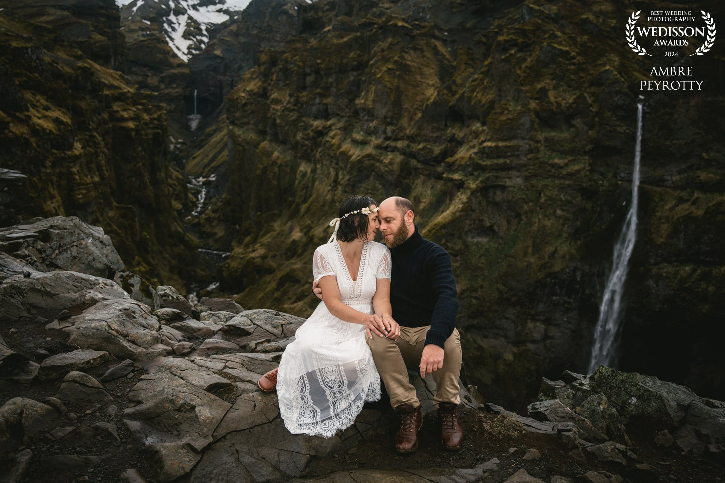 A couple shares a romantic moment during their elopement in Iceland's stunning natural landscape.