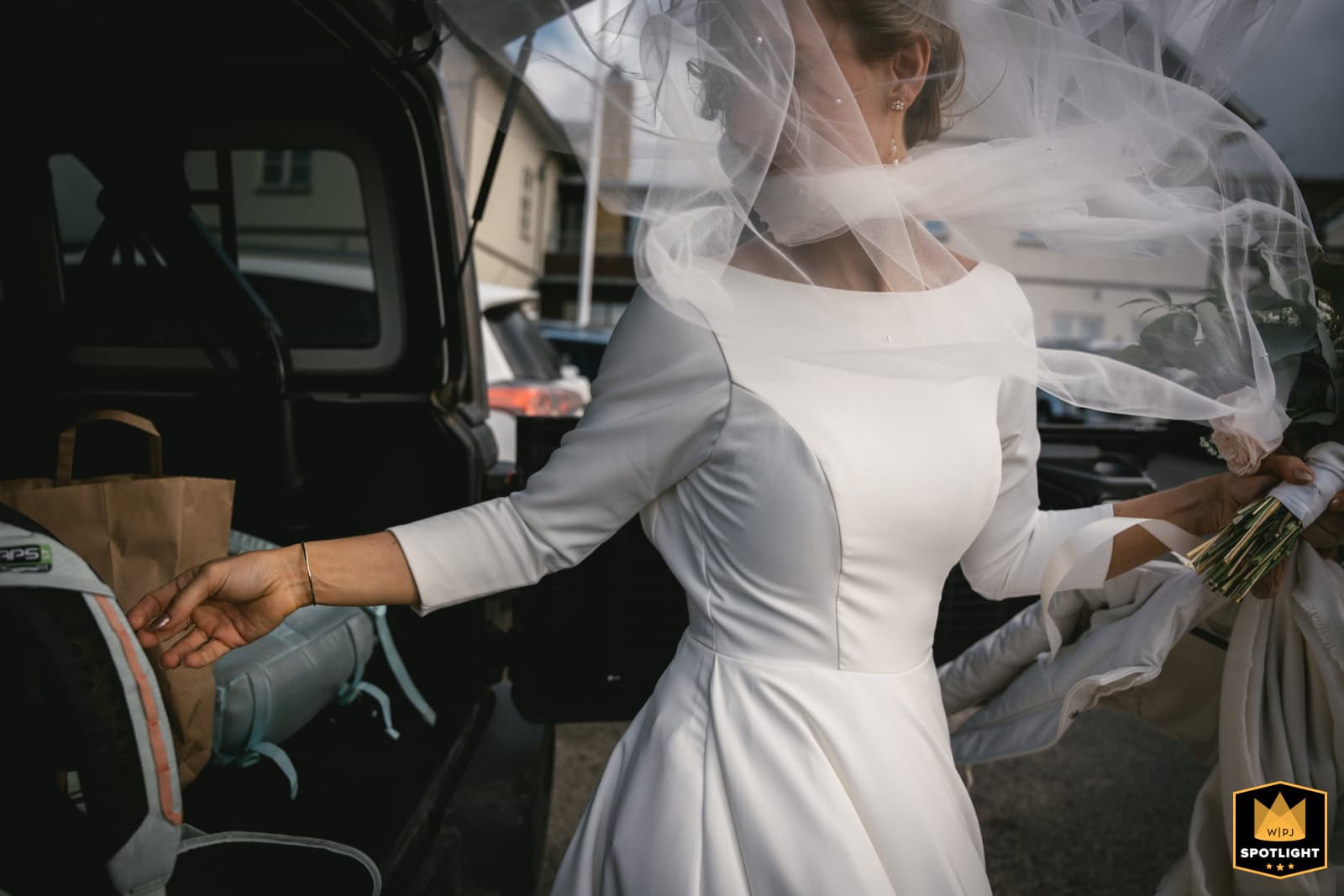 Bride in a white wedding dress with flowing veil preparing for Iceland elopement.