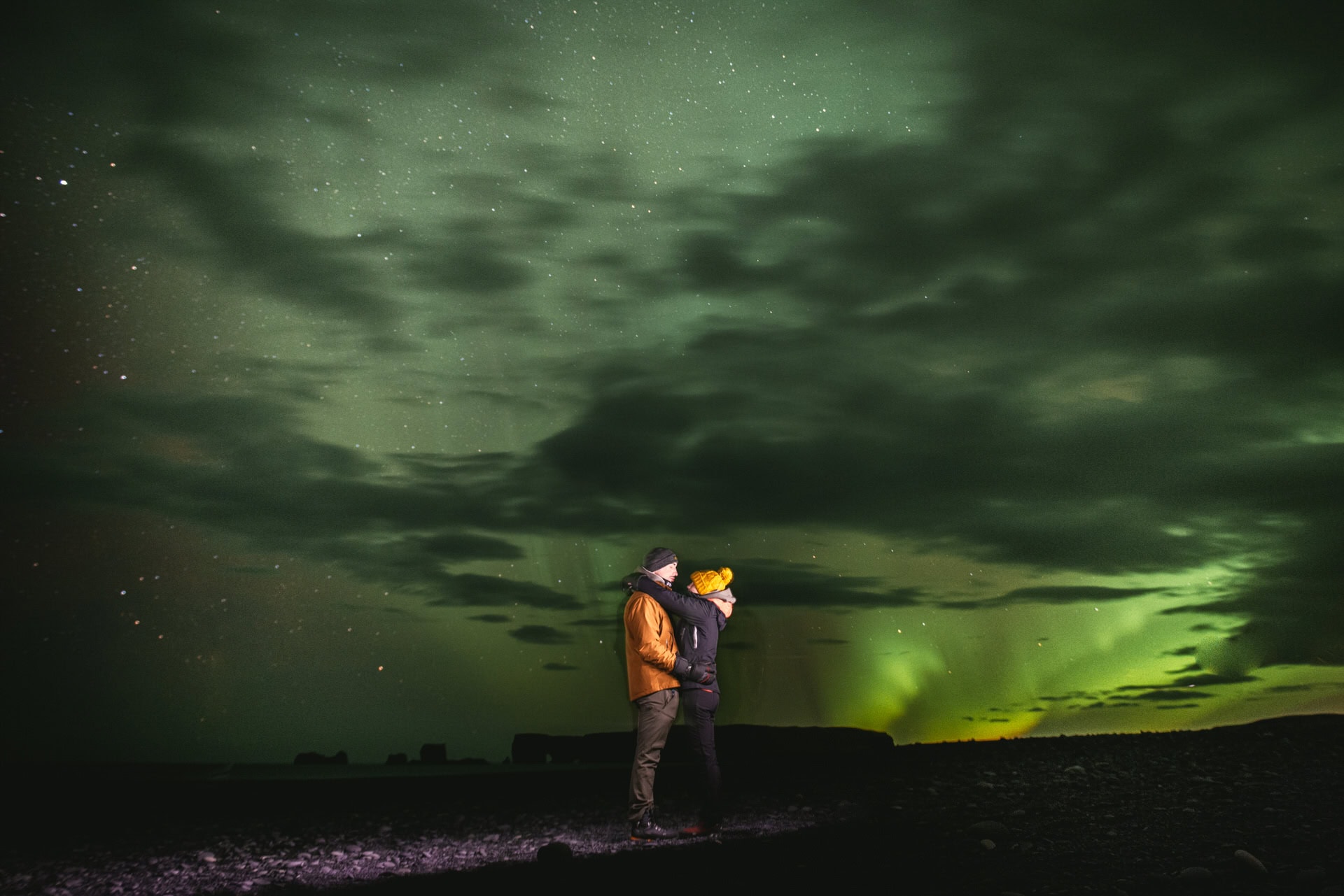 Couple embracing under the Northern Lights in Iceland during an elopement.
