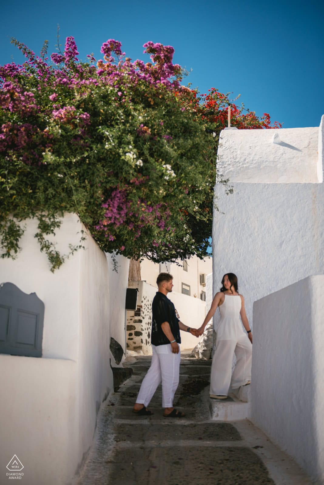 Elopement couple holding hands in a picturesque Greek village.