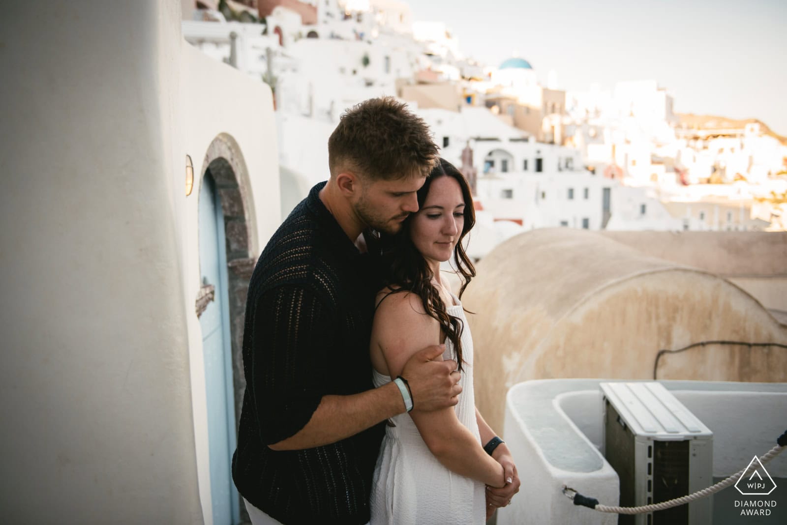 Couple embracing during a Greece elopement on a scenic rooftop.