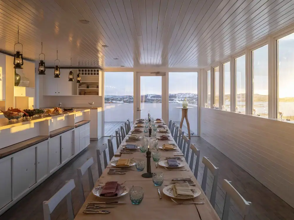 Elopement dinner setup with a long table overlooking a scenic water landscape, perfect for a romanti.