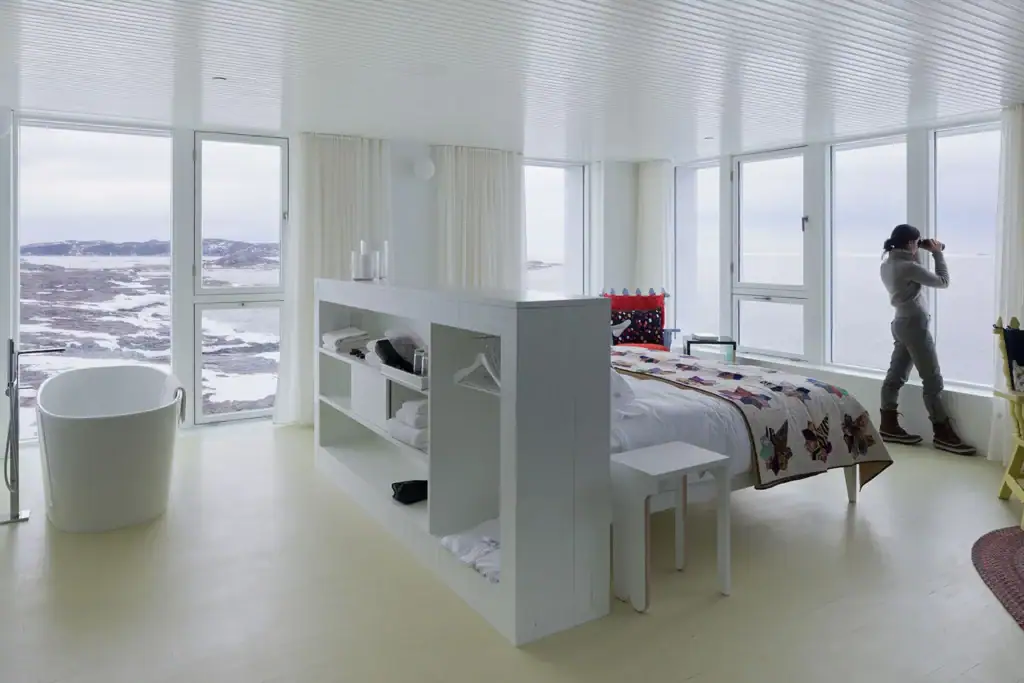 Elegant hotel room with panoramic snowy landscape views.
