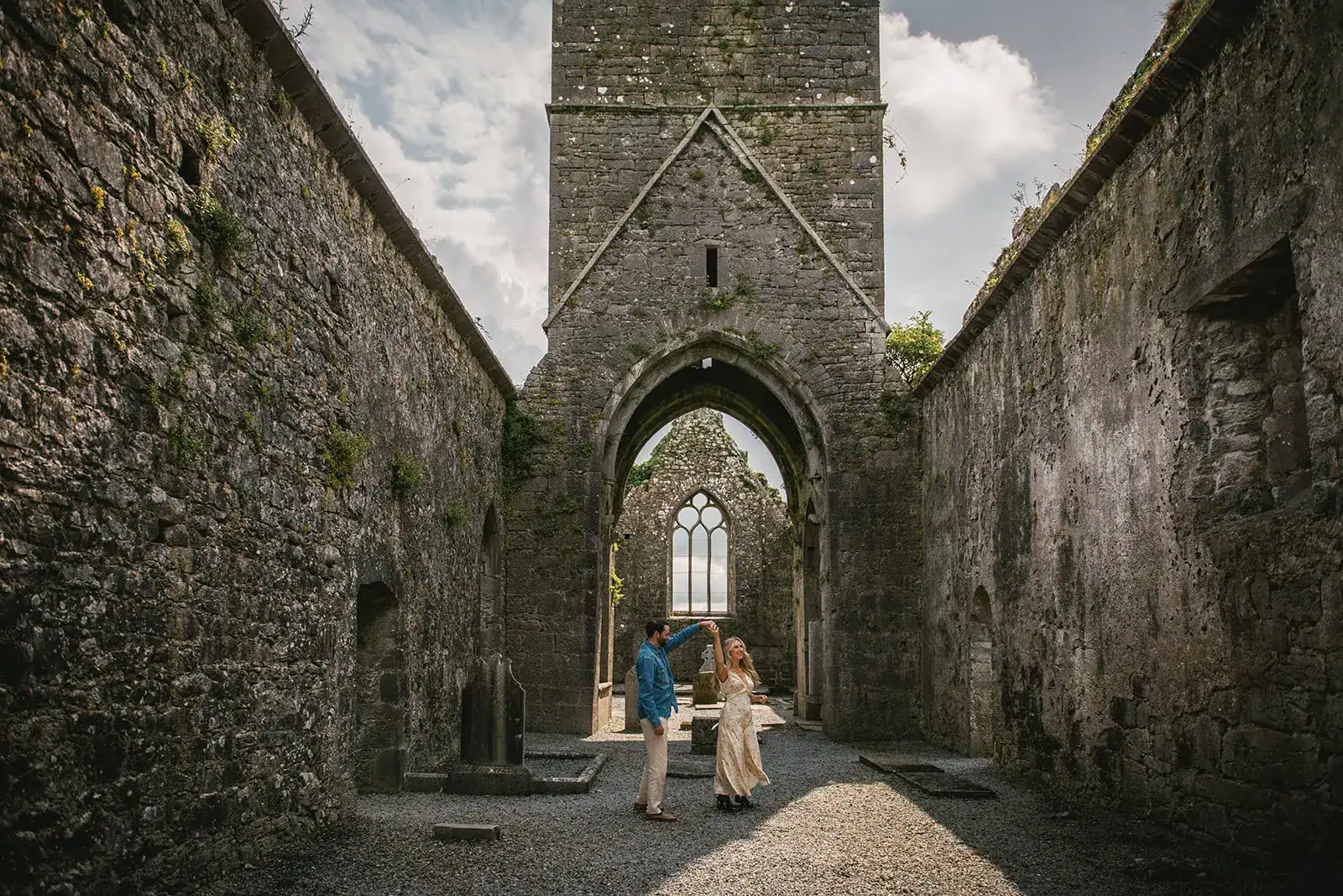 Elopement ceremony at an ancient Irish castle with a couple exchanging vows under a stone arch.
