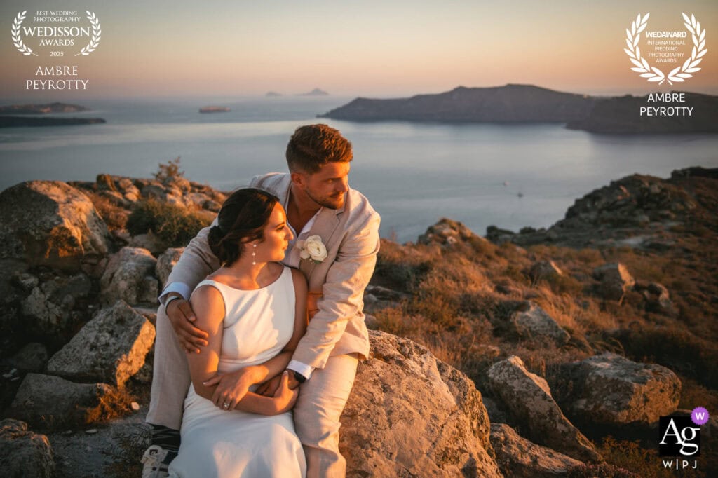 Elegant couple embracing during sunset on rocky coast in Italy, celebrating their elopement.