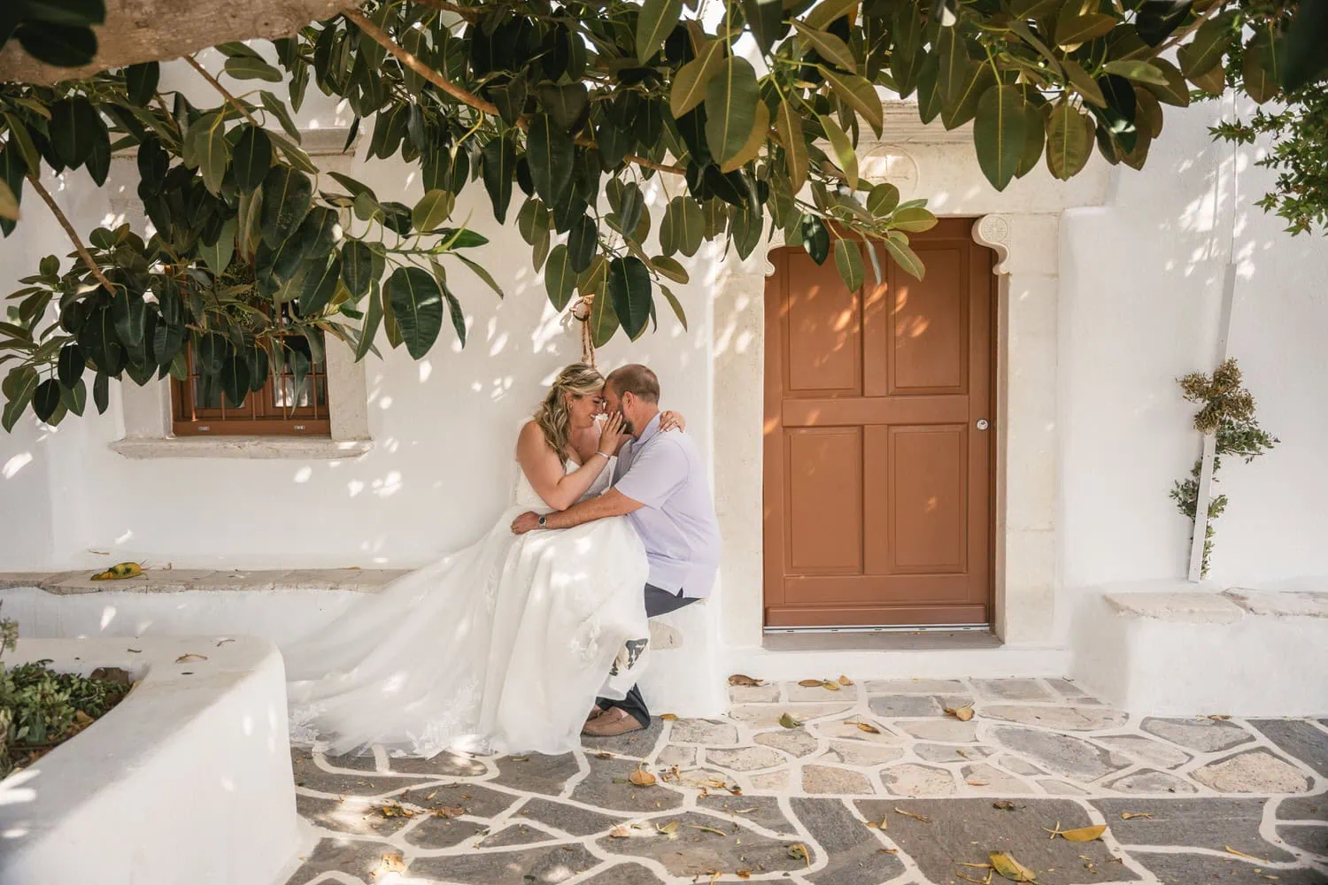 Elopement couple kissing under a tree on Paros, Greece, during sunset.