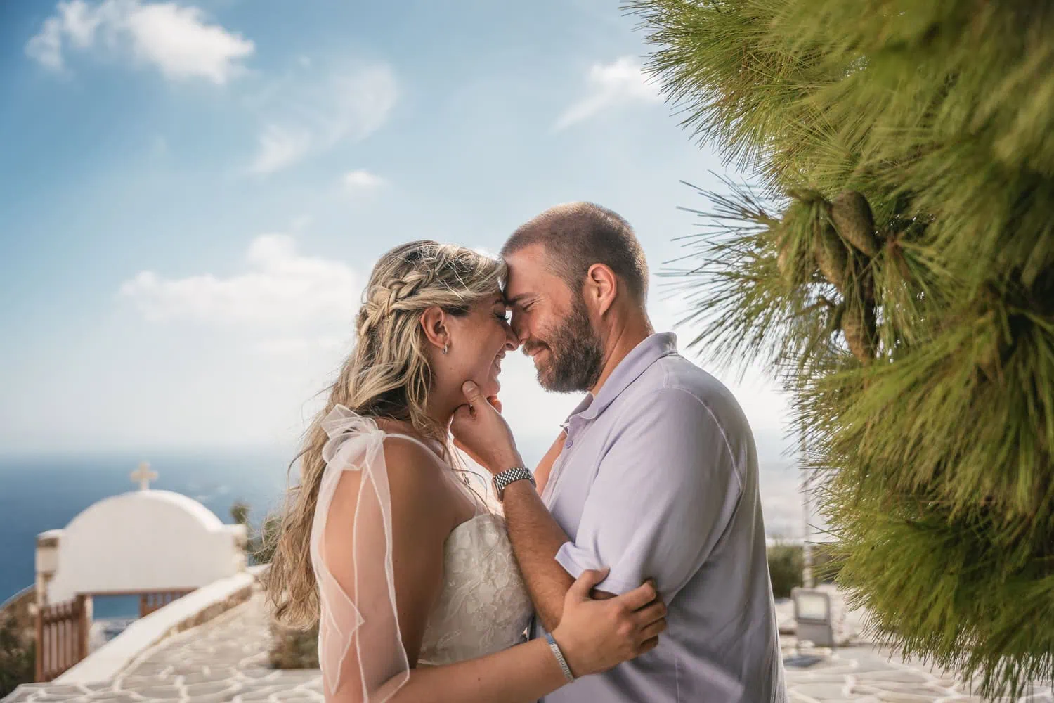 Intimate sunset elopement of a couple on Paros, Greece, with scenic ocean views and traditional arch.