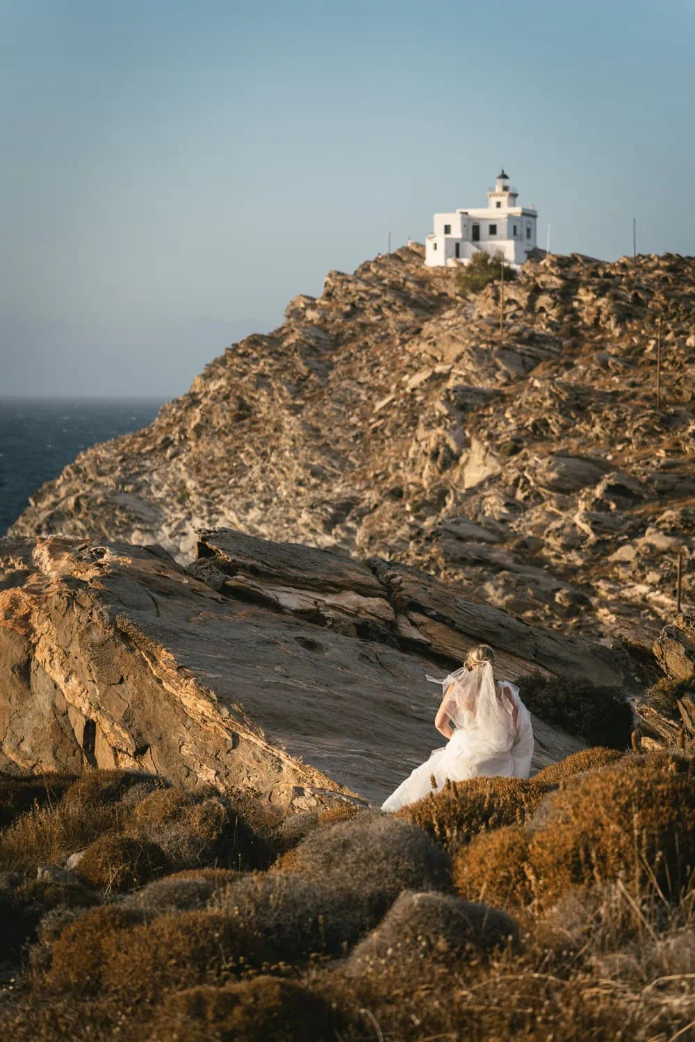 Elopement ceremony at sunset with a bride in a white dress overlooking the Aegean Sea.