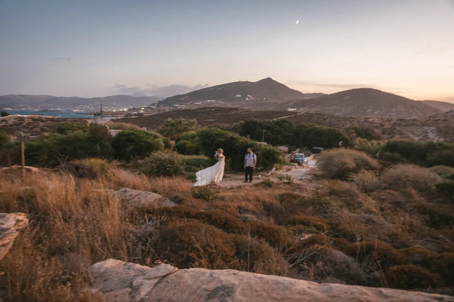 Elopement at sunset on Paros, Greece, with a bride and groom in a scenic landscape.
