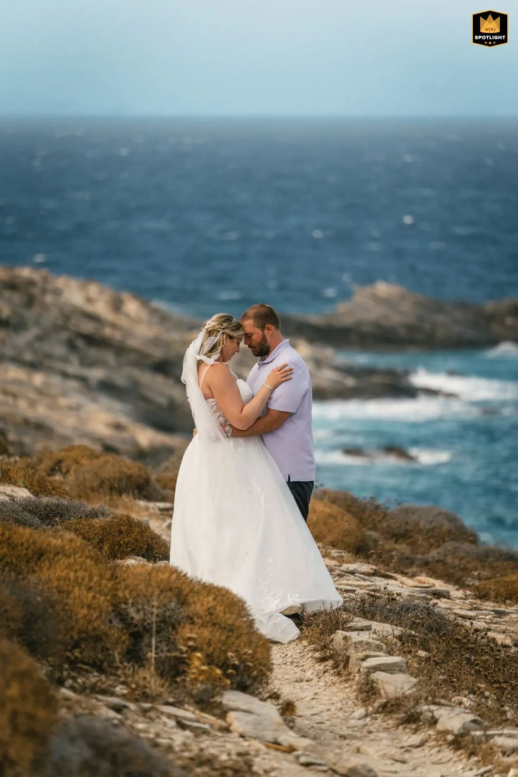 Romantic couple during sunset elopement on Paros, Greece, with ocean view.